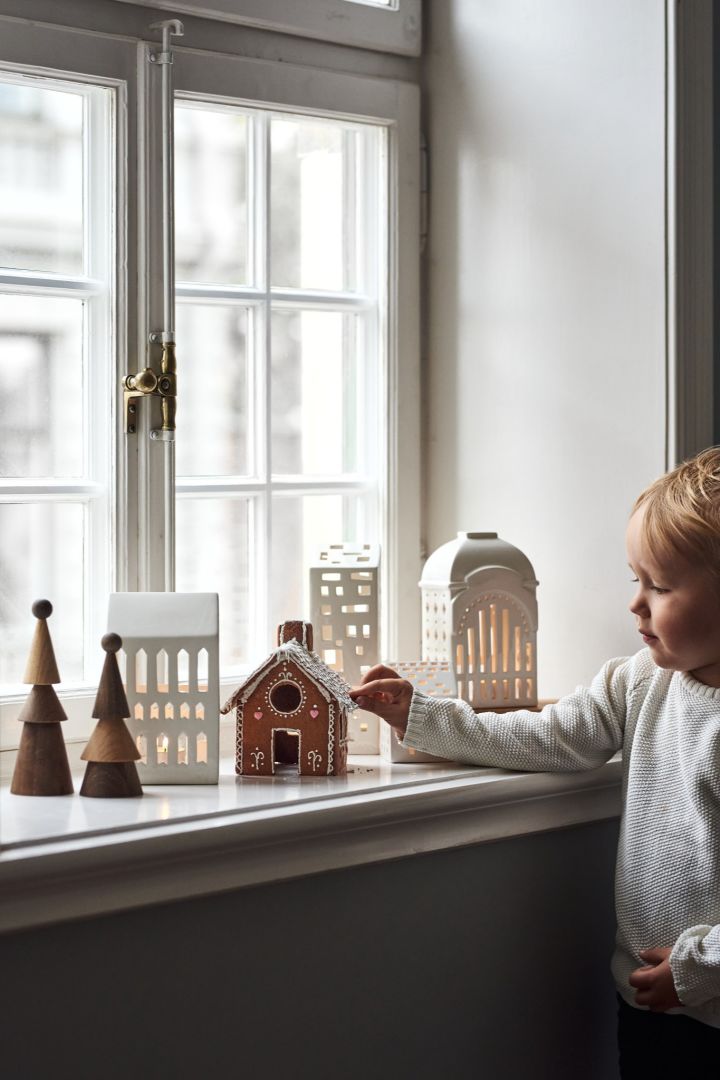 Koristele perinteisillä skandinaavisilla joulukoristeilla, kuten Kählerin Urbania-kynttilänjaloilla. Tässä näet kokoelman niitä ikkunalaudalla nuoren pojan kanssa. 