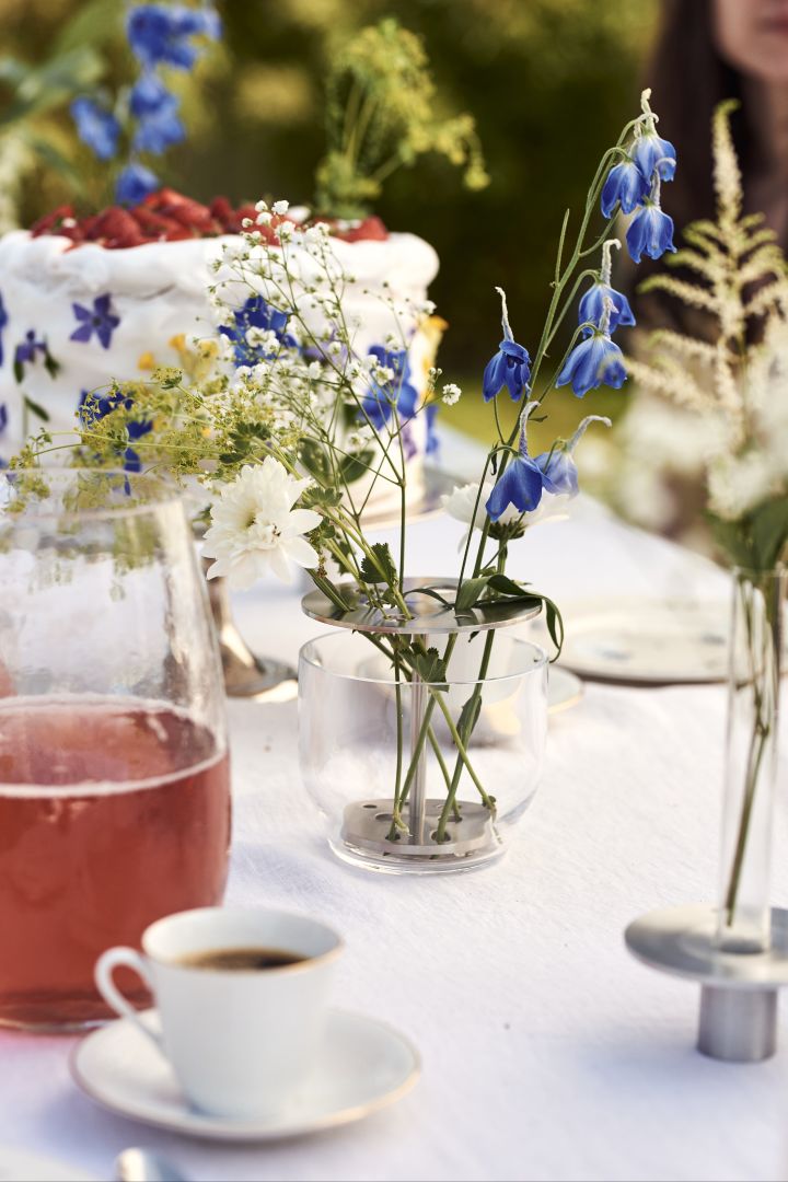 Papin kaulus ja kesäkukkia Ikebana-maljakossa, lasia ja ruostumatonta terästä Fritz Hansenilta.